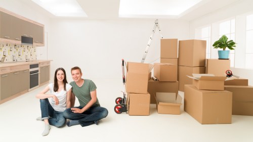 Moving team handling furniture and boxes in a White City apartment move